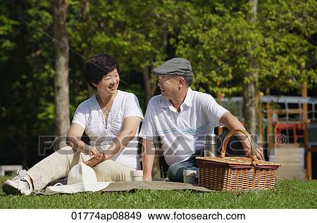 Couple having a picnic in the park View Large Photo Image Stock Photo - Couple having a picnic in the park. Fotosearch