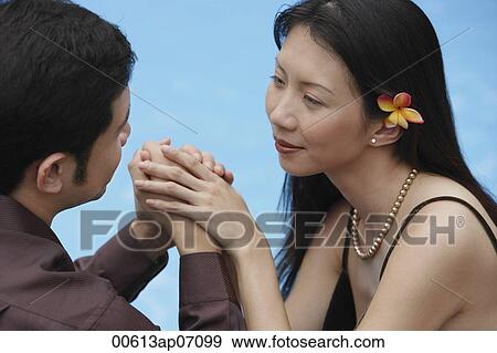 Couple holding hands, looking at each other View Large Photo Image Stock Photo - Couple holding hands, looking at each other. Fotosearch