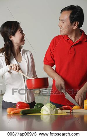 Couple in kitchen, preparing a meal together View Large Photo Image Stock Image - Couple in kitchen, preparing a meal together. Fotosearch