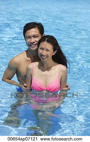 Couple in swimming pool, smiling at camera View Large Photo Image Stock Image - Couple in swimming pool, smiling at camera. Fotosearch