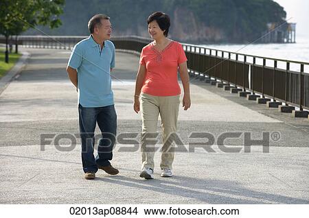 Couple strolling along the waterfront View Large Photo Image Picture - Couple strolling along the waterfront. Fotosearch