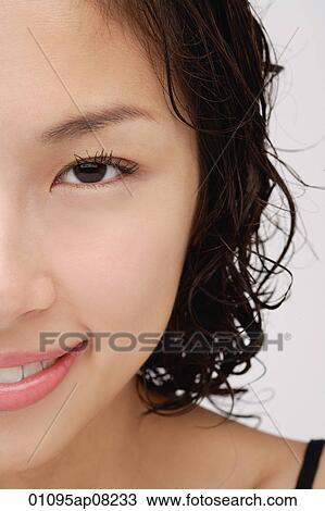 Stock Image - Cropped face of a woman smiling at the camera. Fotosearch