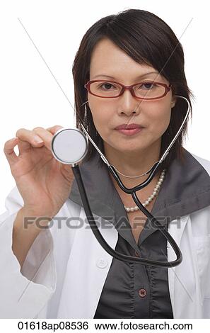 Doctor holding up stethoscope and looking at camera View Large Photo Image Stock Photograph - Doctor holding up stethoscope and looking at camera. Fotosearch