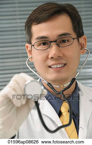Stock Photograph - Doctor with stethoscope smiling at camera. Fotosearch