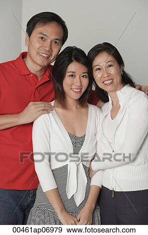 Stock Photo - Family of three, looking at camera, smiling. Fotosearch