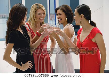 Four women standing and toasting glasses, smiling View Large Photo Image Stock Photo - Four women standing and toasting glasses, smiling. Fotosearch
