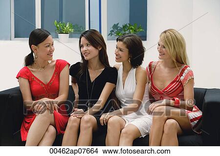 Four young women wearing dresses and sitting on couch View Large Photo Image Picture - Four young women wearing dresses and sitting on couch. Fotosearch