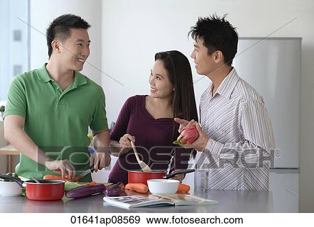 Friends cooking in the kitchen View Large Photo Image Stock Photo - Friends cooking in the kitchen. Fotosearch