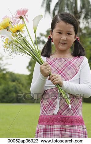 Stock Image - Girl holding bouquet of flowers. Fotosearch