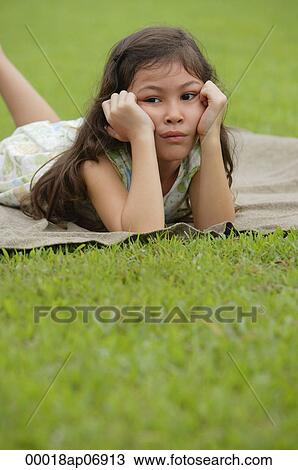 Girl lying on picnic blanket, hands on face, sad expression View Large Photo Image Stock Image - Girl lying on picnic blanket, hands on face, sad expression. Fotosearch