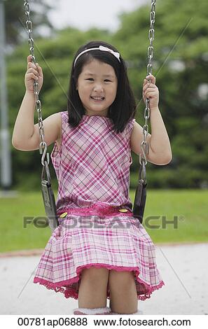 Girl on swing, smiling at camera View Large Photo Image Stock Photo - Girl on swing, smiling at camera. Fotosearch