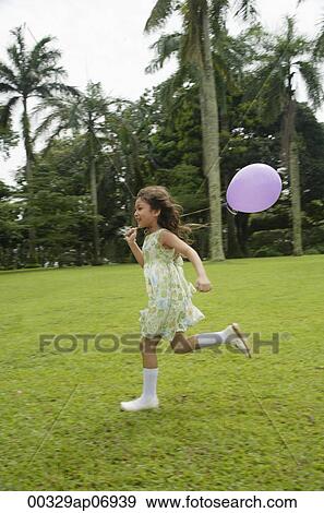 Girl running in park, purple balloon flying behind her View Large Photo Image Stock Photo - Girl running in park, purple balloon flying behind her. Fotosearch