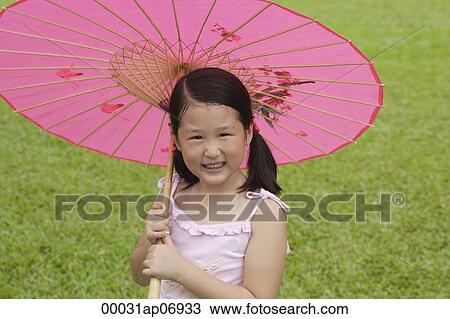 Girl using pink traditional Chinese paper umbrella, looking at camera View Large Photo Image Stock Image - Girl using pink traditional Chinese paper umbrella, looking at camera. Fotosearch