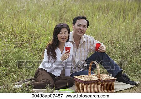 Man and woman having picnic outdoors in nature View Large Photo Image Stock Photo - Man and woman having picnic outdoors in nature. Fotosearch