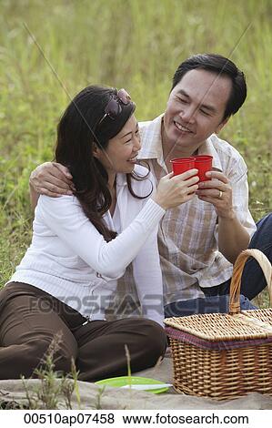 Man and woman having picnic, toasting glasses View Large Photo Image Stock Photo - Man and woman having picnic, toasting glasses. Fotosearch