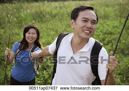 Man and woman hiking outdoors, holding hands, smiling View Large Photo Image Stock Photo - Man and woman hiking outdoors, holding hands, smiling. Fotosearch