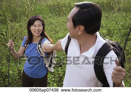 Man and woman hiking outdoors, nature, holding hands, looking at each other View Large Photo Image Stock Photo - Man and woman hiking outdoors, nature, holding hands, looking at each other. Fotosearch