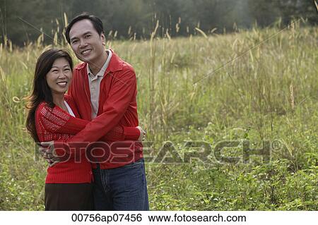 Man and woman hugging each other, standing outdoors in nature, smiling View Large Photo Image Stock Photograph - Man and woman hugging each other, standing outdoors in nature, smiling. Fotosearch
