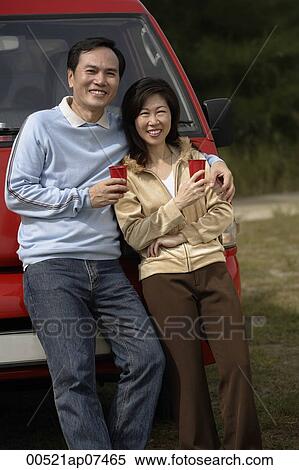 Man and woman leaning against red van, smiling at camera, camping View Large Photo Image Stock Photography - Man and woman leaning against red van, smiling at camera, camping. Fotosearch