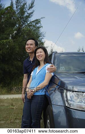 Man and woman leaning against SUV, arm around woman View Large Photo Image Stock Image - Man and woman leaning against SUV, arm around woman. Fotosearch
