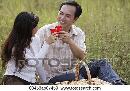 Man and woman outdoors having picnic, toasting glasses and looking at each other View Large Photo Image Stock Photo - Man and woman outdoors having picnic, toasting glasses and looking at each other. Fotosearch