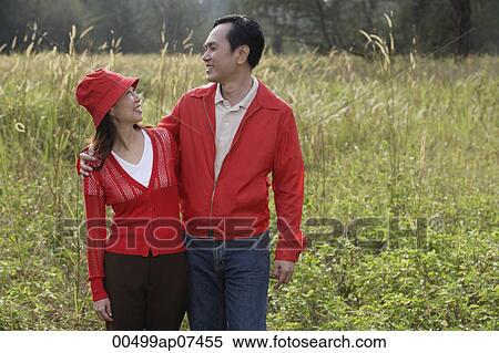 Man and woman standing outdoors in nature, smiling at each other View Large Photo Image Stock Photography - Man and woman standing outdoors in nature, smiling at each other. Fotosearch