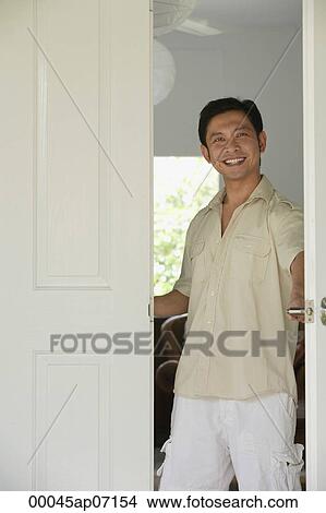 Man at home, standing at doorway, smiling View Large Photo Image Picture - Man at home, standing at doorway, smiling. Fotosearch