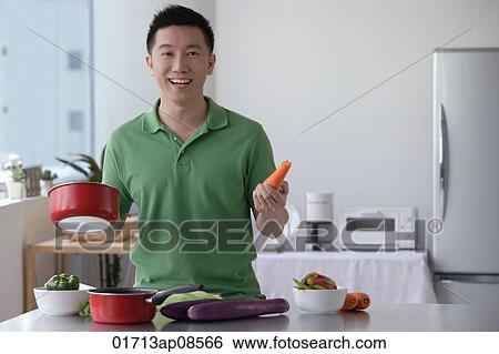 Stock Photograph - Man cooking and smiling at camera. Fotosearch