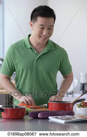 Man cooking in the kitchen View Large Photo Image Stock Photo - Man cooking in the kitchen. Fotosearch