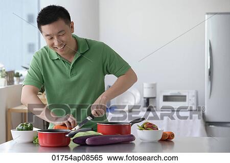 Man cooking in the kitchen View Large Photo Image Stock Photography - Man cooking in the kitchen. Fotosearch