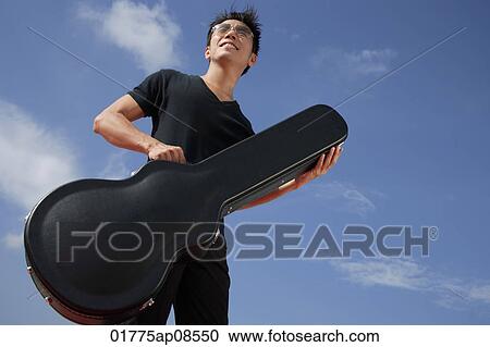 Man holding guitar case View Large Photo Image Stock Image - Man holding guitar case. Fotosearch