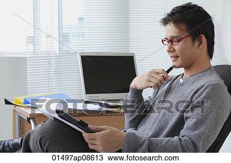 Man in office chair writing on clipboard View Large Photo Image Stock Image - Man in office chair writing on clipboard. Fotosearch
