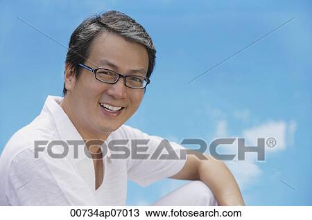 Man in white shirt smiling at camera View Large Photo Image Stock Image - Man in white shirt smiling at camera. Fotosearch