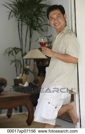Man leaning against doorway, holding glass of wine View Large Photo Image Stock Photograph - Man leaning against doorway, holding glass of wine. Fotosearch