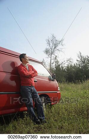 Man leaning against red van, outdoors in nature View Large Photo Image Stock Image - Man leaning against red van, outdoors in nature. Fotosearch