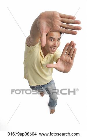 Man making frame with hands while smiling at camera View Large Photo Image Picture - Man making frame with hands while smiling at camera. Fotosearch