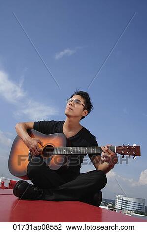 Man playing guitar outdoors View Large Photo Image Stock Image - Man playing guitar outdoors. Fotosearch