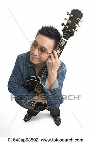 Man smiling while hugging his guitar View Large Photo Image Stock Image - Man smiling while hugging his guitar. Fotosearch
