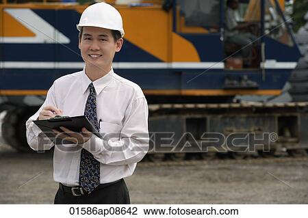Man with hard helmet and clipboard looking at camera View Large Photo Image Stock Image - Man with hard helmet and clipboard looking at camera. Fotosearch