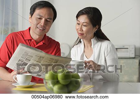 Mature couple at home, looking at newspaper and having coffee View Large Photo Image Stock Image - Mature couple at home, looking at newspaper and having coffee. Fotosearch