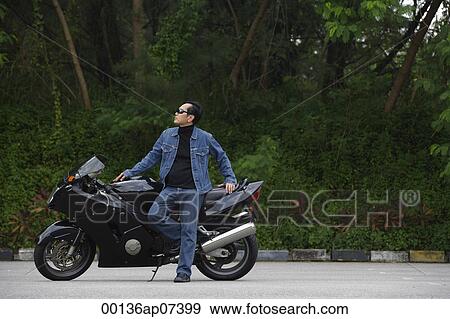 Mature man leaning against motorcycle, wearing sunglasses View Large Photo Image Stock Photo - Mature man leaning against motorcycle, wearing sunglasses. Fotosearch