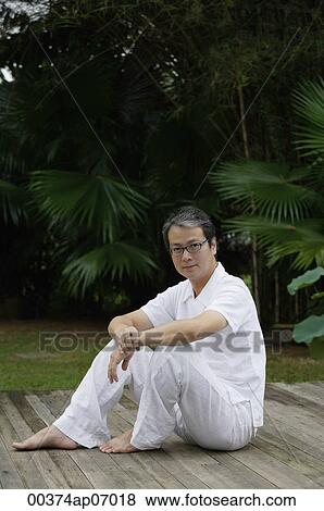 Mature man sitting outdoors in garden, looking at camera View Large Photo Image Stock Photo - Mature man sitting outdoors in garden, looking at camera. Fotosearch