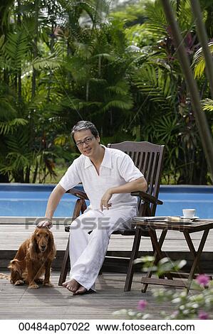 Mature man with his dog, sitting by swimming pool View Large Photo Image Stock Image - Mature man with his dog, sitting by swimming pool. Fotosearch