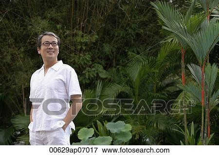 Mature men dressed in white, standing in garden, hands in pockets View Large Photo Image Stock Photo - Mature men dressed in white, standing in garden, hands in pockets. Fotosearch