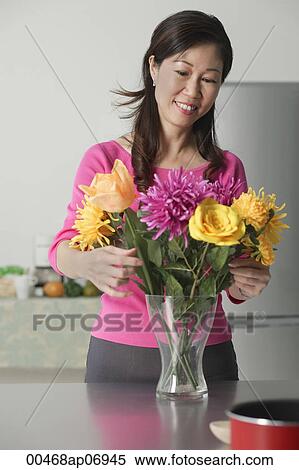 Mature woman arranging flowers in vase View Large Photo Image Stock Photography - Mature woman arranging flowers in vase. Fotosearch