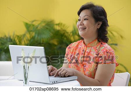 Stock Photography - Mature woman at laptop. Fotosearch