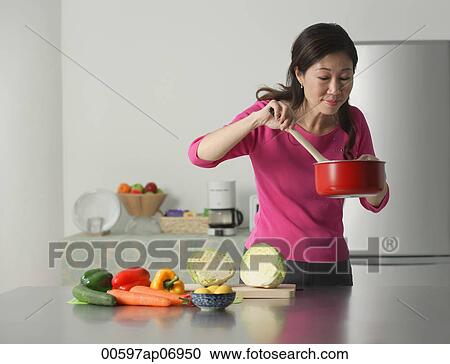 Mature woman cooking in kitchen, looking at contents of pot View Large Photo Image Stock Image - Mature woman cooking in kitchen, looking at contents of pot. Fotosearch