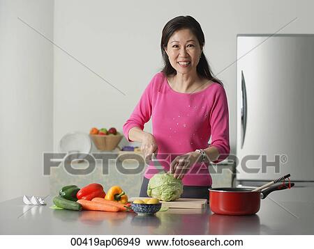 Mature woman in kitchen, preparing food View Large Photo Image Stock Photo - Mature woman in kitchen, preparing food. Fotosearch