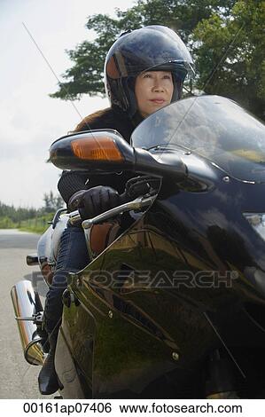 Mature woman riding motorcycle, wearing helmet View Large Photo Image Stock Photograph - Mature woman riding motorcycle, wearing helmet. Fotosearch