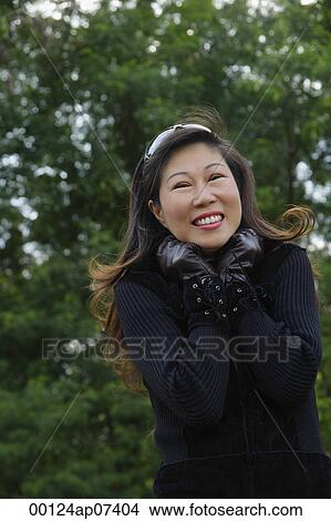 Mature woman wearing leather gloves and smiling at camera, cold View Large Photo Image Picture - Mature woman wearing leather gloves and smiling at camera, cold. Fotosearch